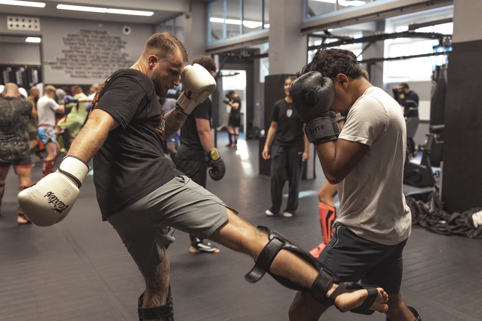 Kickboxer landet im Training einen Lowkick am Bein seines Partners
