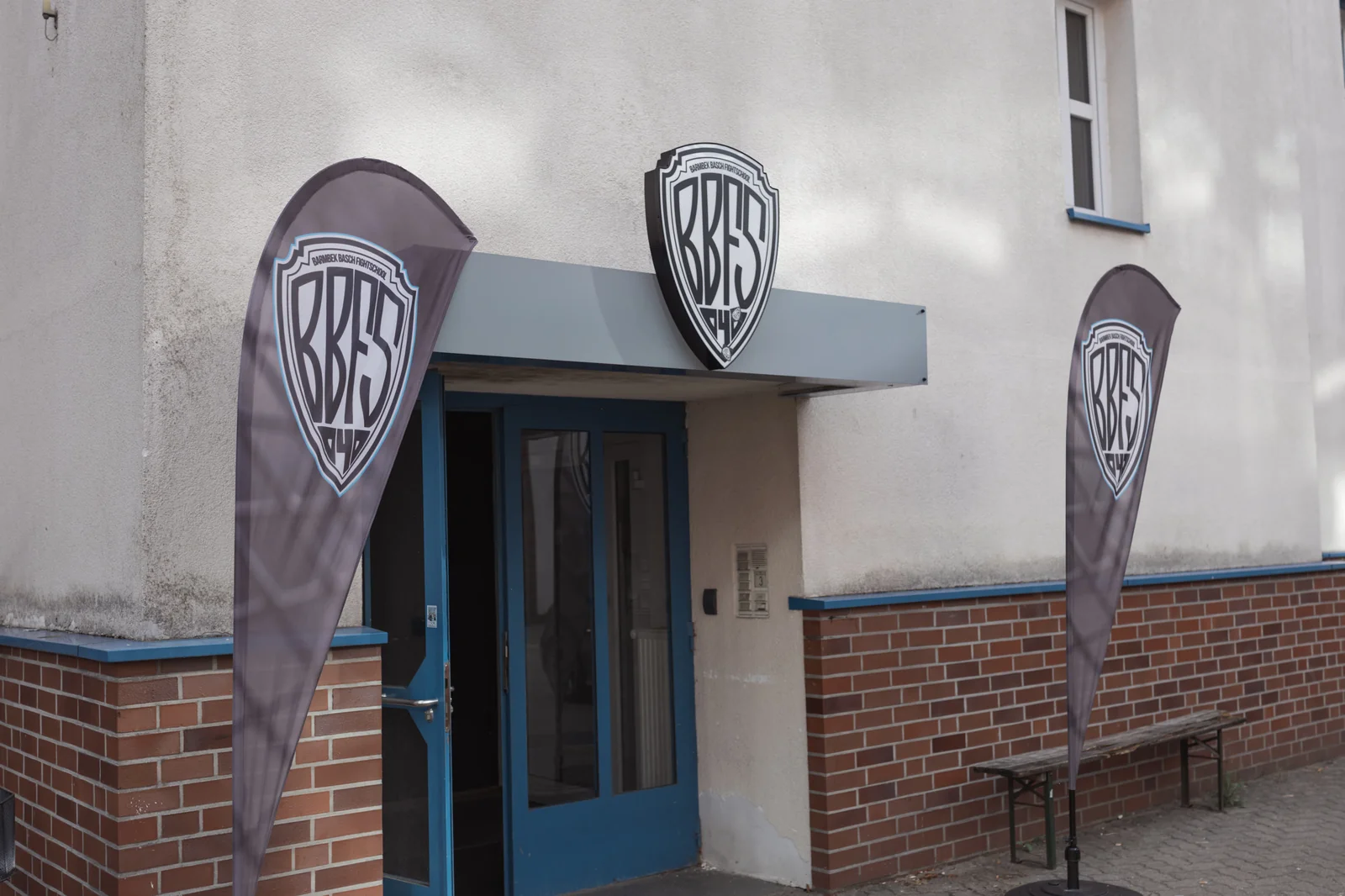 Eingang der Barmbek Basch Fightschool in der Maurienstraße 3 mit BBFS-Beachflags