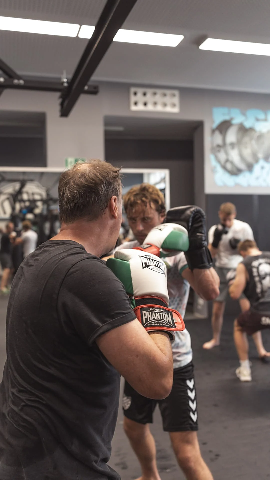 Zwei Erwachsene beim Boxtraining in der Partnerübung mit hoher Deckung