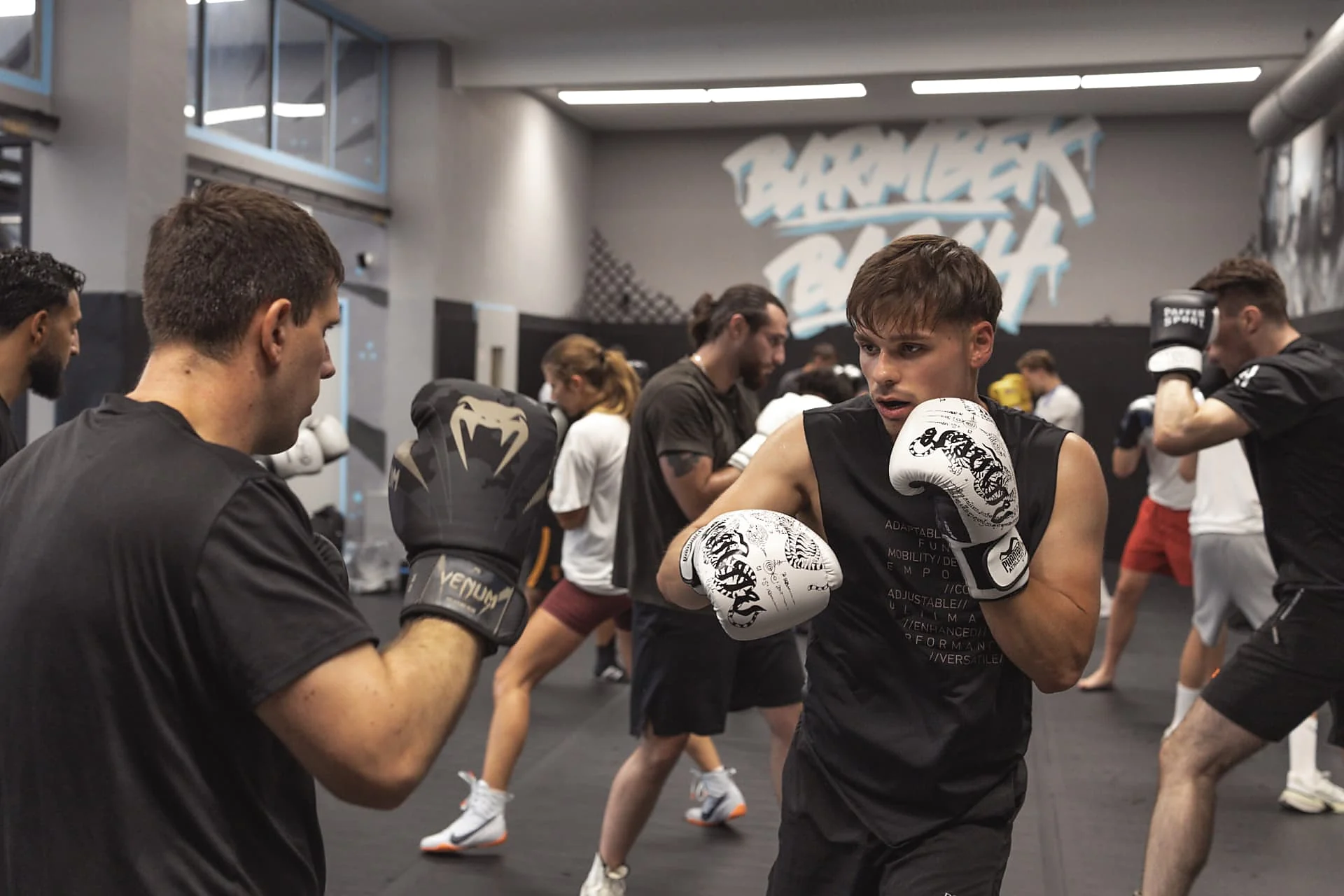 Boxtraining in der Halle: Partnerübung mit Handschuhen vor dem Barmbek-Basch-Wandbild